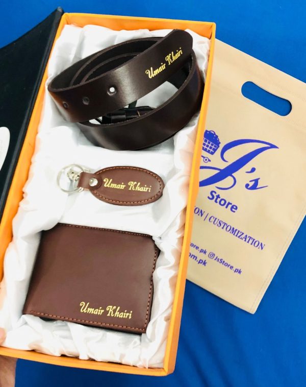 Customized Name Engraved Leather Wallet Keychain Belt Gift Set. It's a Leather gift set that includes a Wallet Keychain and Belt. All the items come with customized Name Engraving, packed in a beautiful gift box. The gift box inner has a white color silk cloth to give it a premium look. The box also has a fine red color edges with black color from outside. The gift set comes with brown leather products and with golden name engraving.