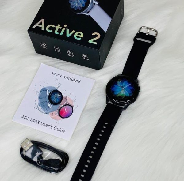 AT-2 Max Smartwatch with Black Strap, showcasing accessories including wireless charger, packaging, and cable, against white background.