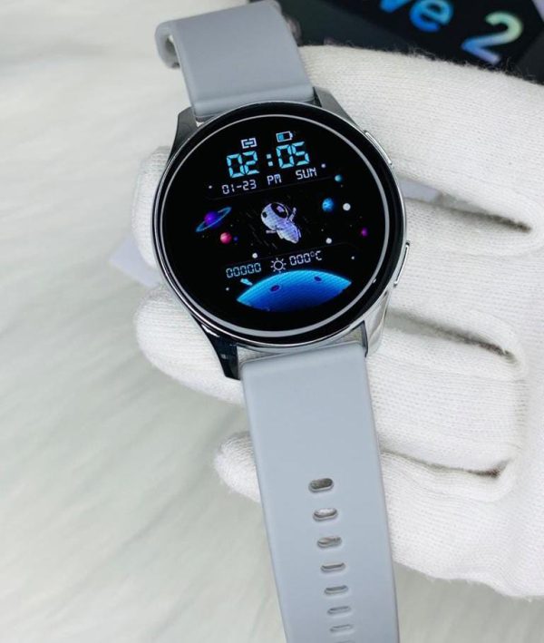 AT-2 Max Smartwatch elegantly presented in hand wearing white gloves, showcasing grey color strap and black dial.
