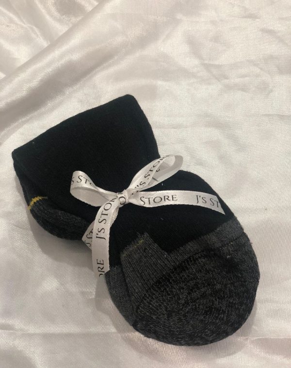 Black and grey socks folded on a crisp white sheet, men's fashion essentials, comfortable style, classic design, J's Store.