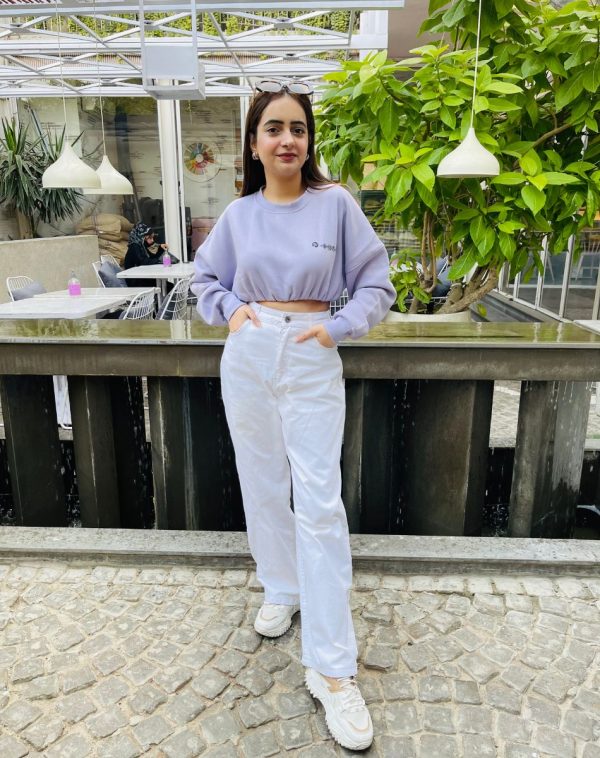 Detailed styling view of Lilac Cropped Drop Shoulder Scannable Sweatshirt, showcasing fleece material. Palvi Ramani's full picture highlights the impeccable design from head to toe.