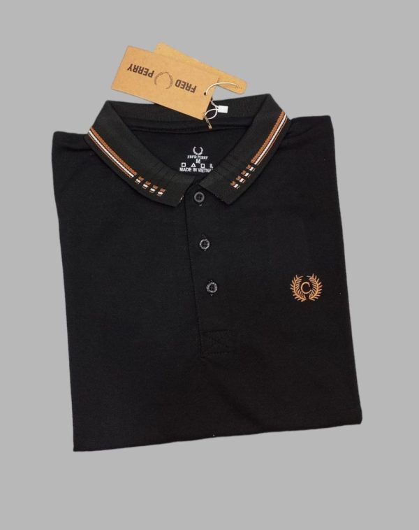 A black polo shirt, with yellow detailing on collar and chest. Placed against a grey background.