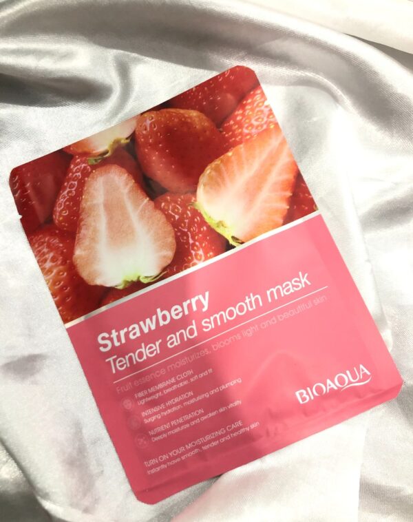 BioAqua Sheet Mask - Strawberry: A pink sachet featuring an image of fresh strawberries and the text "Strawberry Tender and smooth mask." The sachet also displays the BioAqua logo and text describing its moisturizing and skin-beautifying benefits. This is a BioAqua Sheet Mask - Strawberry.