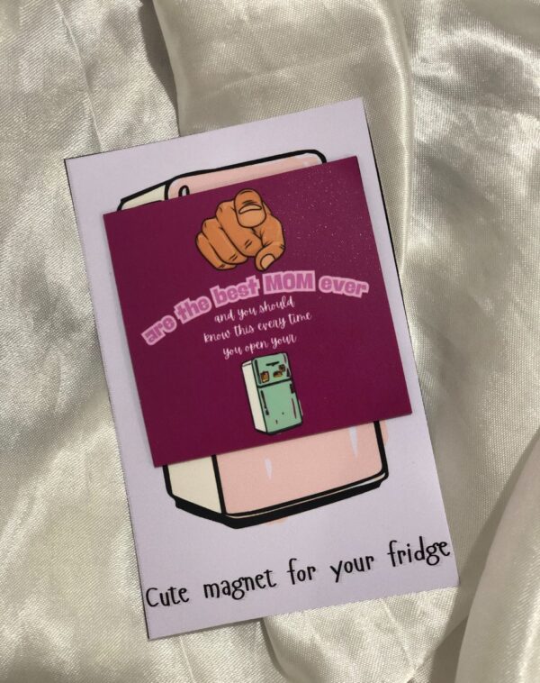 Fridge Magnet for Mother's Day: A small, square, purple fridge magnet with a cartoon hand pointing and the text "are the best MOM ever and you should know this every time you open your" along with a drawing of a small refrigerator. It is presented on a white card with the text "Cute magnet for your fridge". This is a Fridge Magnet for Mother's Day.