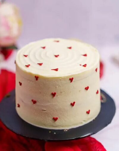 Perfectly Red Velvet Cake topped with small red hearts, ideal for special occasions.