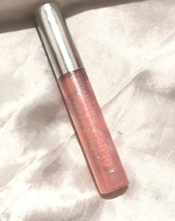 A transparent tube of sparkling, glittery light pink lip gloss.