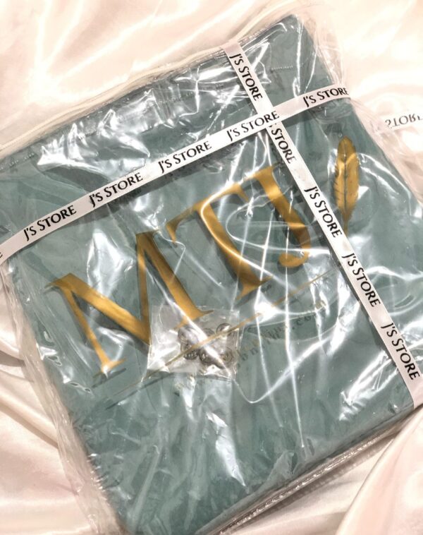 An unstitched men's suit from the brand MTJ. The suit is a mint green color and is packaged in plastic.