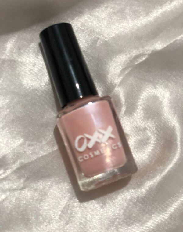 A small, square bottle of pink nail paint from Oxx Cosmetics.
