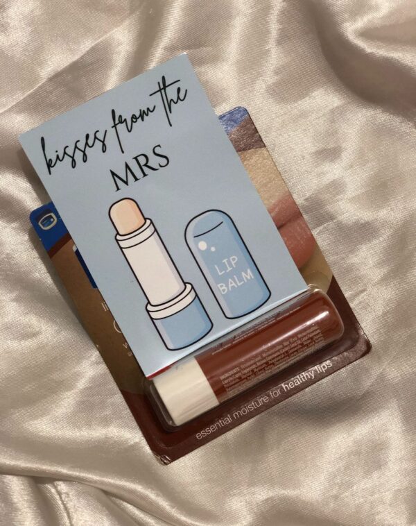 A container of Vaseline Lip Balm with Shea Butter. It is attached to a blue card that says 'Kisses from the MRS'.