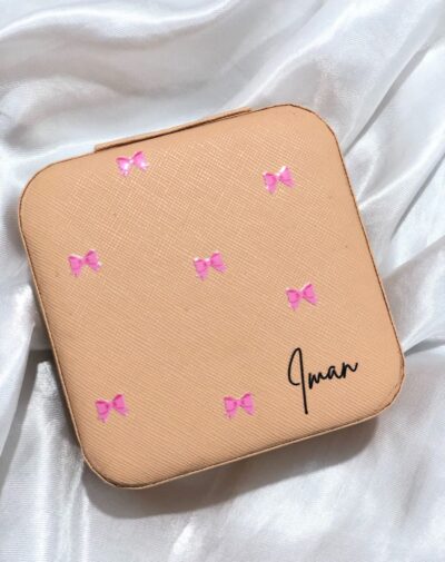 Customized Jewelry Organizer in a nude pink leather finish with a bow pattern and the custom name "Iman."