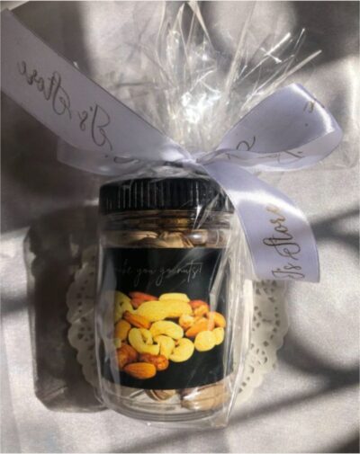 Dry Fruits Jar from J’s Store filled with mixed nuts, tied with a white and gold custom ribbon.
